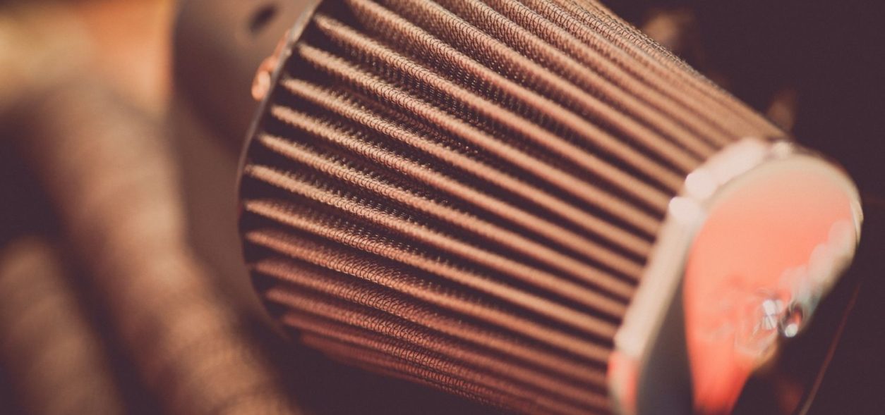 Person cleaning a motorcycle air filter.