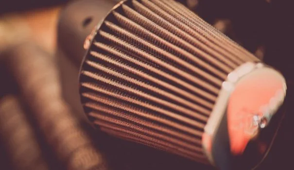 Person cleaning a motorcycle air filter.
