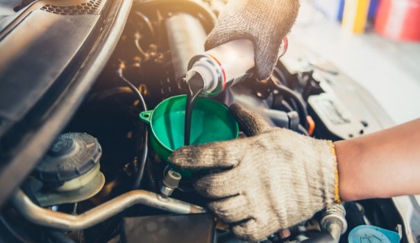Man pouring engine assembly lube into a car.
