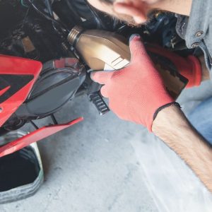 Person changing the oil in a motorcycle.