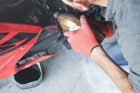 Man changing the oil in his motorcycle.