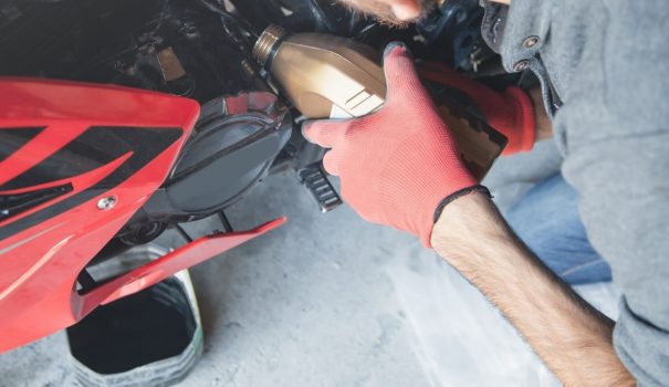 Man changing the oil in his motorcycle.