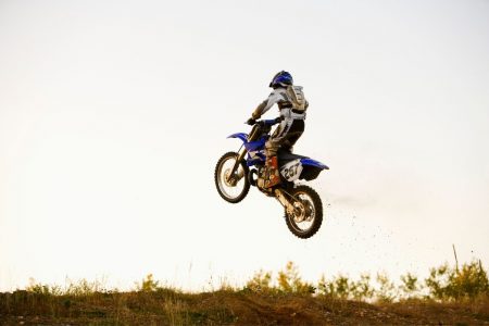 Person riding a dirt bike in an open field.