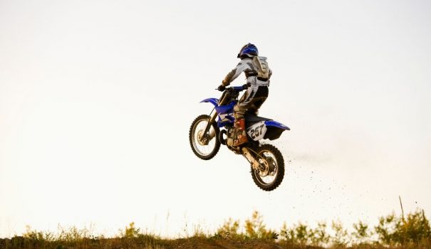 Person riding a dirt bike in an open field.