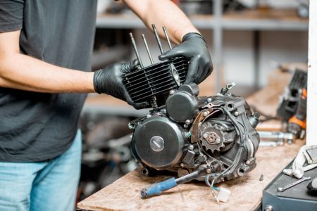 Person working on a motorcycle engine.