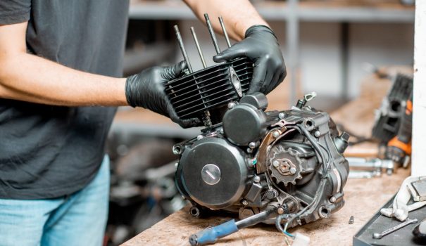 Person working on a motorcycle engine.
