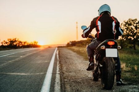 Man pulled to teh side of the road on a motorcycle