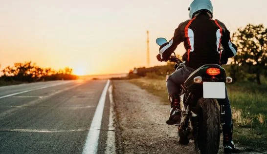 Man pulled to teh side of the road on a motorcycle